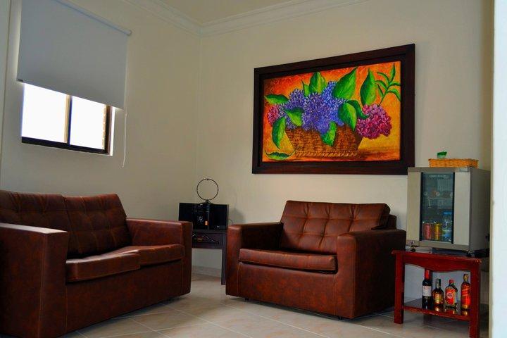 Casa Morales Hotel Internacional Y Centro De Convenciones اباغويه المظهر الخارجي الصورة A living room with a sofa and armchair